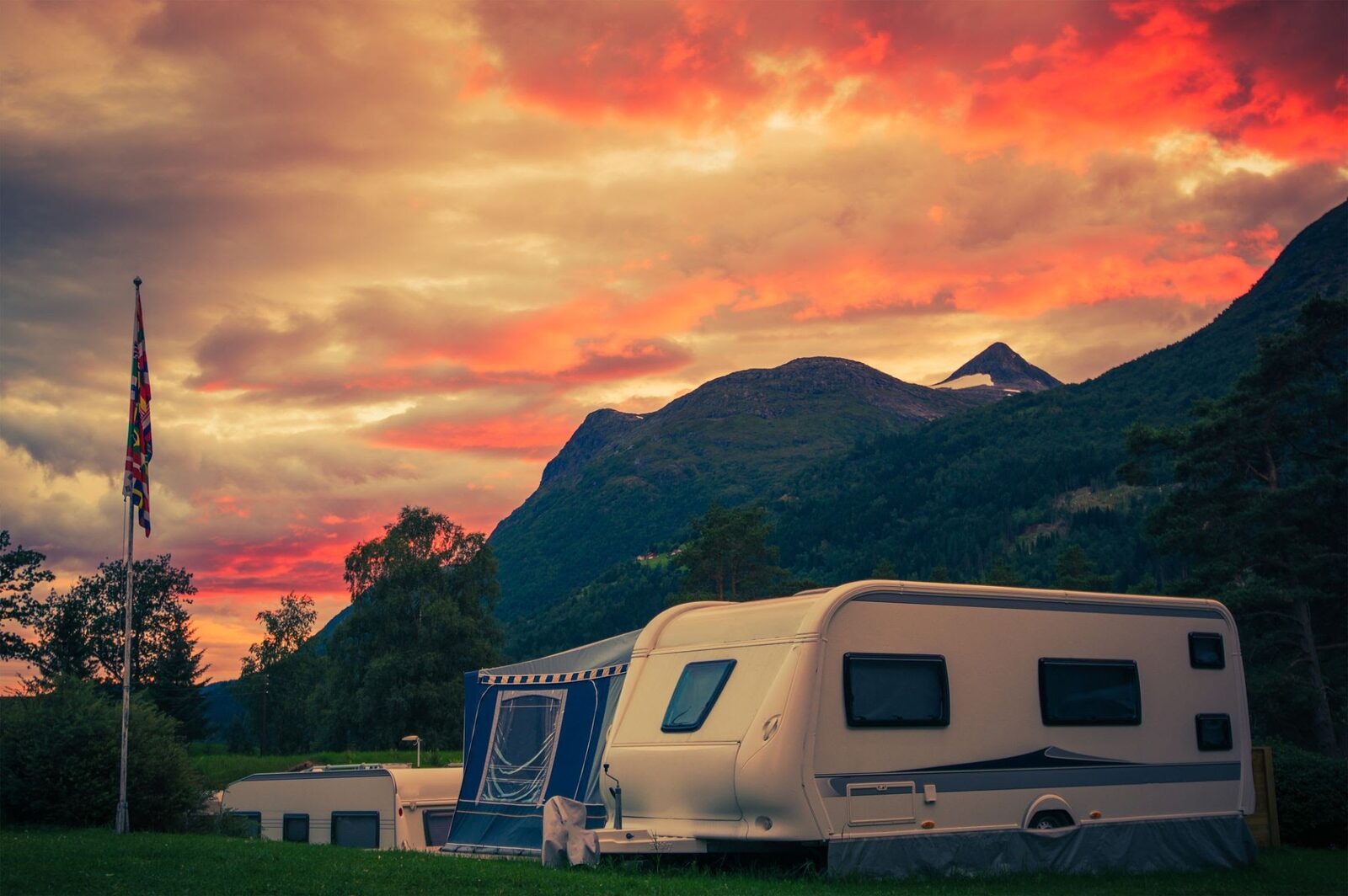 An RV parked at a mountain campsite under a fiery sunset insurance — InsureToday24, insuretoday24.com